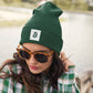 a woman wearing a bit swagg bitcoin square beanie in spruce green